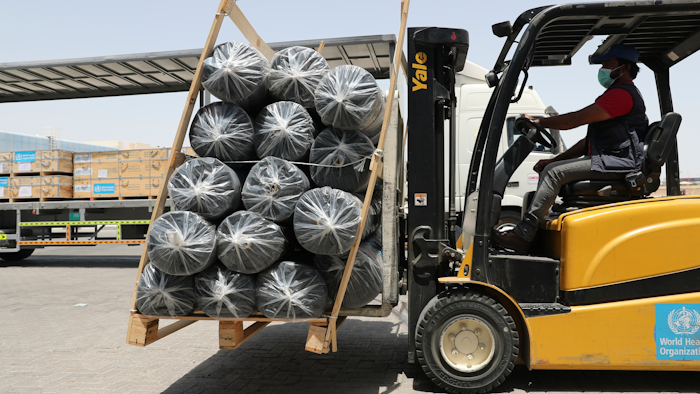 A forklift driver loads material for temporary shelters to be sent to India.