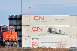 In this May 13 photo, a Canadian National locomotive passes by freight containers at the Canadian National Taschereau yard in Montreal.