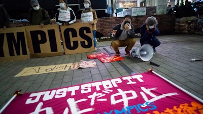 In this March 25, 2021, file photo, a 'No Olympics' banner is placed by protesters in Tokyo during a demonstration against the going ahead of the Tokyo 2020 Olympic and Paralympic Games. An online petition calling for the Tokyo Olympics to be canceled has gained ten of thousands of signatures since being launched in Japan just a few days ago. The rollout comes with Tokyo, Osaka and several other areas under a state of emergency with coronavirus infections rising — particularly new variants.