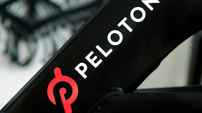 This Nov. 19, 2019 file photo shows a Peloton logo on the company's stationary bicycle in San Francisco. Peloton is recalling its treadmills after one child died and 29 other children suffered from cuts, broken bones and other injuries from being pulled under the rear of the treadmill. The U.S. Consumer Product Safety Commission said Wednesday, May 5, 2021, that Peloton received 72 reports of adults, kids, pets or other items, such as exercise balls, being pulled under the treadmill.