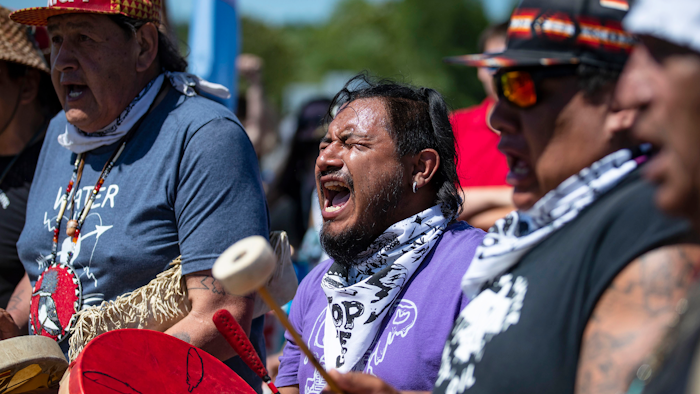 Jesse Barrientez, aka Red Feather, center, plays the drums and sings tribal songs with other Indigenous people during a march, Clearwater County, Minn., June 7, 2021.