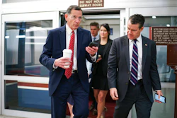 Sen. John Barrasso, R-Wyo., left, and Sen. Todd Young, R-Ind., rush to the chamber for votes at the Capitol in Washington, May 27, 2021.
