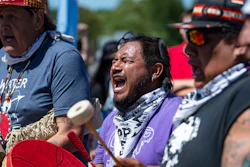Jesse Barrientez, aka Red Feather, center, plays the drums and sings tribal songs with other Indigenous people during a march, Clearwater County, Minn., June 7, 2021.