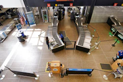 In this May 18, 2020 photo, a lone traveler goes through a security check point at Seattle Tacoma International Airport, in SeaTac, Wash.