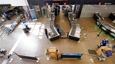 In this May 18, 2020 photo, a lone traveler goes through a security check point at Seattle Tacoma International Airport, in SeaTac, Wash.