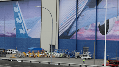 In this Monday, March 23, 2020, file photo, a worker walks near a mural of a Boeing 777 airplane at the company's manufacturing facility in Everett, Wash., north of Seattle.