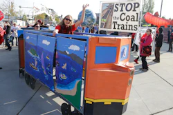 In this Oct. 17, 2013, file photo, a protester rides in a mock coal train as other protesters demonstrate against trains carrying coal for export moving through Washington state in Tacoma, Wash.