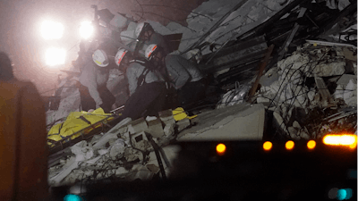 Rescue workers remove a body from the rubble where a wing of a 12-story beachfront condo building collapsed, Thursday, June 24, 2021, in the Surfside area of Miami.