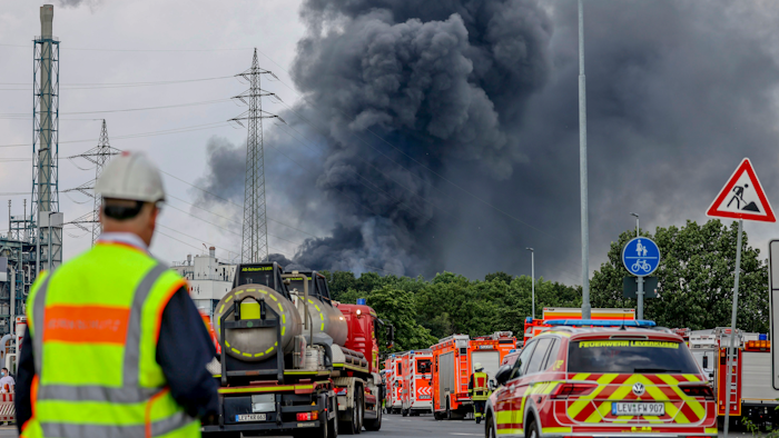 Einsatzfahrzeuge in der Nähe einer Zufahrtsstraße zum Chempark, als eine dunkle Rauchwolke aufsteigt, Leverkusen, Deutschland, 27. Juli 2021.