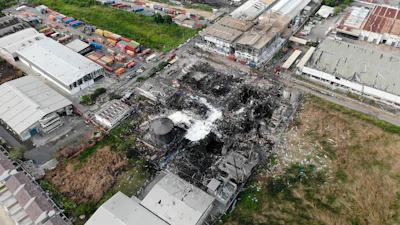 In this drone aerial photo provided by the Disaster Response Associations Thailand, twisted metal frames are all that remains of a burnt chemical factory Tuesday, July 6, 2021, in Samut Prakan, Thailand. Firefighters finally extinguished a blaze at a chemical factory just outside the Thai capital early Tuesday, more than 24-hours after it started with an explosion that damaged nearby homes and then let off a clouds of toxic smoke that prompted a widespread evacuation.