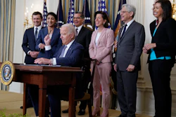 President Joe Biden hands out a pen after signing an executive order, State Dining Room, White House, July 9, 2021.