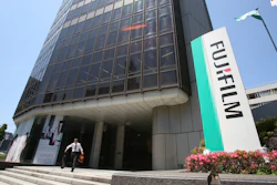 In this May 14, 2018, file photo, a man walks in front of Nishiazabu headquarters of Fujifilm Holdings Corporation in Tokyo.