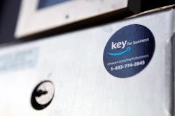 A blue sticker with the Amazon logo is displayed on a buzzer system in the apartment building of Jason Goldberg, chief commerce strategy officer at marketing company Publicis Communications, Monday, March 29, 2021, in Chicago. Amazon is making a push to install a device on buzzer systems in apartment buildings throughout the country that allows its delivery drivers to whip out a phone, tap a button and unlock a building's front doors whenever they need to leave packages in the lobby instead of the street.