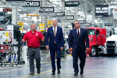 President Joe Biden walks with Mack Trucks President Martin Weissburg, right, and UAW Local 677 Shop Chairman Kevin Fronheiser, left, during a tour of the Lehigh Valley operations facility for Mack Trucks in Macungie, PA on Wednesday, July 28.