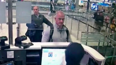 This Dec. 30, 2019, image from security camera video shows Michael L. Taylor, center, and George-Antoine Zayek at passport control at Istanbul Airport in Turkey.