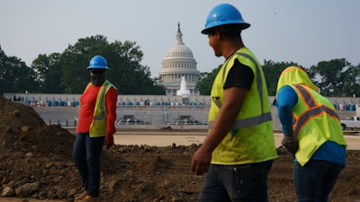 Workers repair a park near the Capitol in Washington, Wednesday, July 21, 2021. About 8 in 10 Americans favor plans to increase funding for roads, bridges and ports and for pipes that supply drinking water.