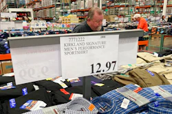 A sign displays the price for shirts as a shopper peruses the offerings at a Costco warehouse on Thursday, June 17, 2021, in Lone Tree, Colo. American consumers faced a third straight monthly surge in princes in June, the latest sign that a rapid reopening of the economy is fueling a pent-up demand for goods and services that in many cases remain in short supply.
