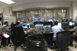University of Colorado and Air Force Research Lab teams in the control room during a dual-mode ramjet ground test. The modified dual frequency comb system is in the center foreground, and is sending light to the test cell, which is located beyond the control room windows.