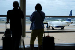 In this Tuesday, May 25, 2021, file photo, travelers watch a JetBlue Airways aircraft taxi away from a gate at Ronald Reagan Washington National Airport†ahead of Memorial Day weekend.