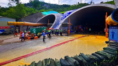 Rescuers build embankments to pump out water from a flooded tunnel in Zhuhai city in south China's Guangdong province Friday, July 16, 2021. Divers have been dispatched in the search for 14 workers missing since water flooded a tunnel under construction in southern China three days ago, authorities said Sunday, July 18, 2021.