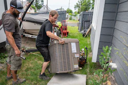 Carl Rocha, left, and Patrick Plummer, with Bills Heating & A/C Install air conditioning and a new furnace at a home on East Wabash Street, Wednesday, June 23, 2021, in Spokane, Wash.
