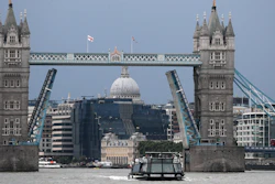 A boat sails down the River Thames in London, Monday Aug. 9, 2021 in front of Tower Bridge that is stuck in the fully open position due to a technical fault.