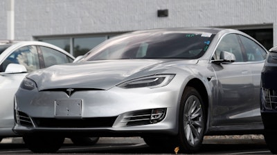 This July 8, 2018, file photo shows Tesla 2018 Model 3 sedans sitting on display outside a Tesla showroom in Littleton, Colo. The U.S. government has opened a formal investigation into Tesla's Autopilot partially automated driving system, saying it has trouble spotting parked emergency vehicles.