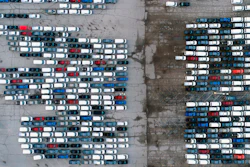 In this March 24 photo, mid-sized pickup trucks and full-size vans are seen in a parking lot outside a General Motors assembly plant where they are produced in Wentzville, Mo.