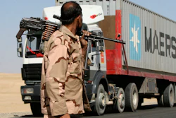 A private security contractor watches a NATO supply truck in the province of Ghazni, Afghanistan, Oct. 27, 2010.