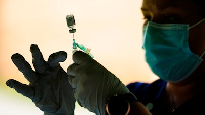 In this Sept. 14, 2021 photo, a syringe is prepared with the Pfizer COVID-19 vaccine at a clinic at the Reading Area Community College in Reading, Pa.