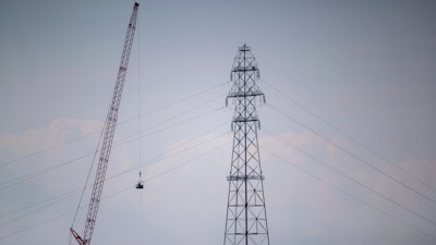 In this Friday, Sept. 3, 2021, file photo, Entergy contractors prepare to detonate transmission lines that fell into the Mississippi River Harahan, in New Orleans, after a tower collapsed during Hurricane Ida.