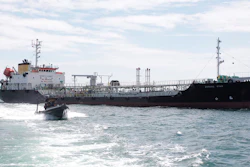 In this undated photo released by Indonesian Navy, a navy boat sails past Panamanian-flagged tanker MT Zodiac Star anchored in Riau Island waters, Indonesia. Indonesian navy seized the massive tanker believed to be loaded with thousands of tons of wasted black oil and has brought the ship to shore for further investigation, officials said Thursday, Sept. 2, 2021.