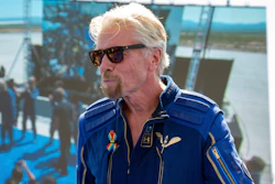 In this July 11, 2021, file photo Virgin Galactic founder Richard Branson shows his Virgin Galactic made astronaut wings pin after his flight to space from Spaceport America near Truth or Consequences, N.M. Virgin Galactic says the Federal Aviation Administration has cleared it to resume launches after an investigation into why its spaceship veered off course while descending during a July flight over New Mexico with Branson aboard.