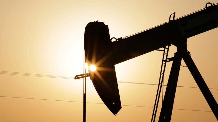 In this Wednesday, Sept. 30, 2015 file photo, an oil pump works at sunset in the desert oil fields of Sakhir, Bahrain. A U.N.-backed study has found that the world needs to cut by more than half its production of coal, oil and gas in the coming decade to maintain a chance of keeping global warming from reaching dangerous levels.
