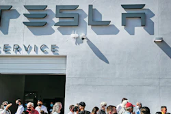 Tesla owners, Tesla employees and local political leaders gather at the service bay doors during an event on Sept. 9, 2021, to celebrate a partnership between Tesla and the Nambé Pueblo after the electric car company repurposed a defunct casino into a sales, service and delivery center near Santa Fe, N.M. Tesla has opened a store on tribal land in New Mexico, sidestepping car dealership laws that prohibit car companies from selling directly to customers.