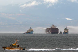 Ships work to control a fire onboard the MV Zim Kingston about 8 kilometers (5 miles) from the shore in Victoria, British Columbia, Canaeda, on Sunday, Oct. 24, 2021. The container ship caught fire on Saturday and 16 crew members were evacuated and brought to Ogden Point Pier.