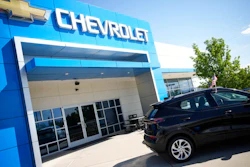 In this Sunday, Sept. 12, 2021, file photo, a pair of unsold 2022 Bolt electric vehicles sit outside a Chevrolet dealership in Englewood, Colo. U.S. new vehicle sales tumbled in September as a global shortage of computer chips worsened, shuttering factories and limiting the selection on dealer lots.