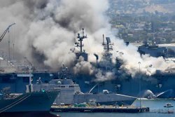 In this July 12, 2020, file photo, smoke rises from the USS Bonhomme Richard at Naval Base San Diego in San Diego, after an explosion and fire on board the ship at Naval Base San Diego. A Navy report has concluded there were sweeping failures by commanders, crew members and others that fueled the July 2020 arson fire that destroyed the USS Bonhomme Richard, calling the massive five-day blaze in San Diego preventable and unacceptable.