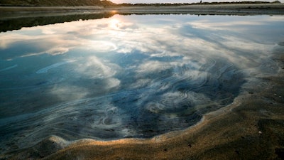Oil floats on the water surface after an oil spill in Huntington Beach, Calif., on Monday, Oct. 4, 2021. A major oil spill off the coast of Southern California fouled popular beaches and killed wildlife while crews scrambled Sunday, to contain the crude before it spread further into protected wetlands.