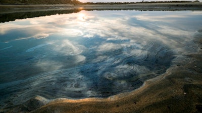 Oil floats on the water surface after an oil spill in Huntington Beach, Calif., on Monday, Oct. 4, 2021. A major oil spill off the coast of Southern California fouled popular beaches and killed wildlife while crews scrambled Sunday, to contain the crude before it spread further into protected wetlands.