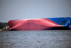 In this Sept. 9, 2019, file photo, a Moran tugboat nears the stern of the capsizing cargo ship Golden Ray as rescuers can be seen near the bottom of the ship near the tug boat, off St. Simons Island, Ga. The final giant chunk of an overturned cargo ship has been removed from waters along the coast of Georgia.