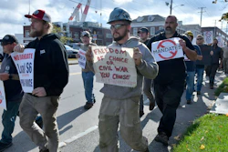 Justin Paetow, center, a tin shop worker at Bath Iron Works, takes part in a demonstration against COVID-19 vaccine mandate outside the shipyard on Friday, Oct. 22, 2021, in Bath, Maine.