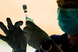 In this Sept. 14, 2021, file photo, a syringe is prepared with the Pfizer COVID-19 vaccine at a clinic at the Reading Area Community College in Reading, Pa. Companies with at least 100 workers will be required to give employees paid time off to get vaccinated against COVID-19 and paid sick leave if they have side effects from the shots. That's according to a Biden administration official who spoke Monday, Nov. 1, about pending vaccine-mandate rules from OSHA, the Occupational Safety and Health Administration.
