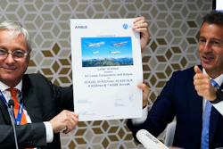 Airbus chief commercial officer Christian Scherer, left, and Airbus CEO Guillaume Faury react after signing a commemorative paper marking a deal at the Dubai Air Show in Dubai, United Arab Emirates, Monday, Nov. 15, 2021.