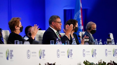 Britain's Alok Sharma, second left, President of the COP26 and Patricia Espinosa, left, UNFCCC Executive-Secretary applaud during the closing plenary session at the COP26 U.N. Climate Summit, in Glasgow, Scotland, Saturday, Nov. 13, 2021. Government negotiators from nearly 200 countries have adopted a new deal on climate action after a last-minute intervention by India to water down the language on cutting emissions from coal.