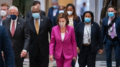 Speaker of the House Nancy Pelosi, D-Calif., center, joined from left by House Majority Leader Steny Hoyer, D-Md., and House Majority Whip James Clyburn, D-S.C., walks to update reporters after day of delays in the vote to advance President Joe Biden's $1.85 trillion-and-growing domestic policy package, at the Capitol in Washington, Friday, Nov. 5, 2021.