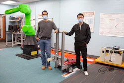 UC engineering students Sam King, left, and Yufeng Sun stand next to the autonomous robot they are building. Sun developed a successful AI that could find and open doors. Now he is translating his simulation to real-world hardware.