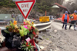 Workers walks past a bouquet of flowers for victims of mine explosion at the Pike River mine at Greymouth, New Zealand on June 28, 2011.