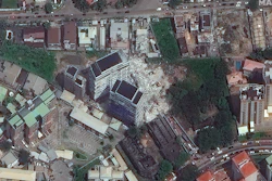 This satellite image provided by Maxar Technologies shows the close up of a collapsed building, center, in Lagos, Nigeria on Wednesday, Nov. 3, 2021. The 21-story luxury apartment building under construction toppled Monday and it took several hours for officials to launch the rescue effort.