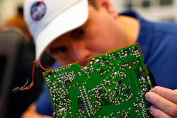 A volunteer repairs a circuit board at a fortnightly repair café event in Malmo, southern Sweden, Sunday Nov. 14, 2021.